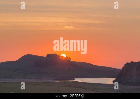 Alba sopra Hotbank Crags, con Crag Lough in primo piano, il Muro di Adriano, Northumberland, Regno Unito Foto Stock