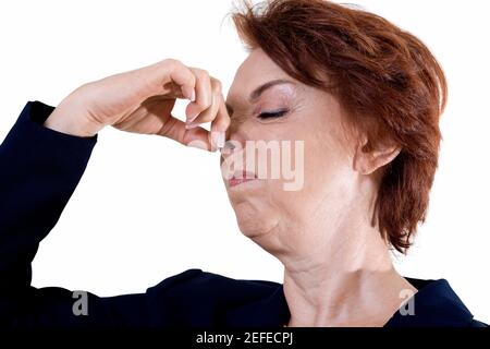 Primo piano di una donna d'affari che tiene il naso Foto Stock