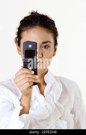 Close-up di una giovane donna che guarda a un telefono cellulare Foto Stock