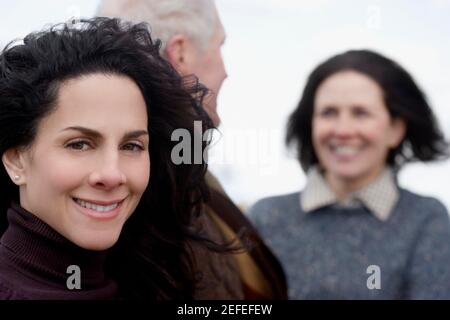 Primo piano di una donna matura con una coppia dietro di lei Foto Stock