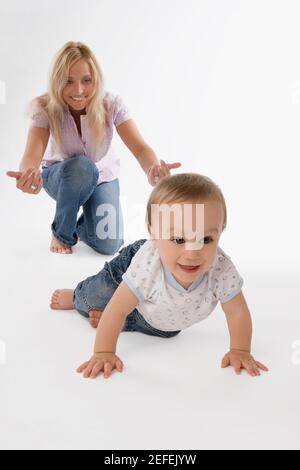 Donna mid adulta che gioca con il suo bambino e sorridente Foto Stock