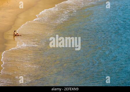 Vista ad alto angolo di una persona seduta sulla spiaggia, Plage du Miramar, Biarritz, Francia Foto Stock