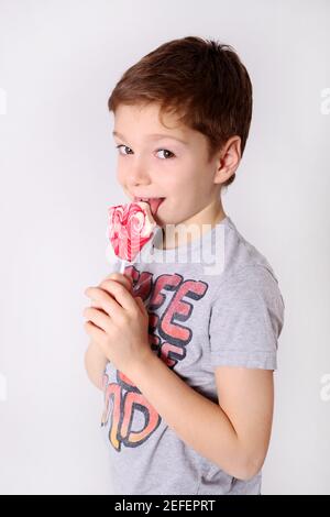 Ragazzino con dolce caramella rosa Foto Stock