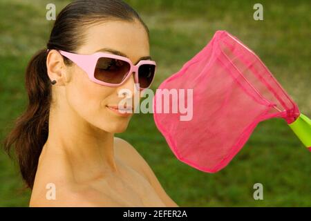 Primo piano di una donna mid adulta con una rete di farfalle Foto Stock