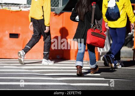 Vista in sezione bassa di una donna e due uomini che camminano in viaggio Foto Stock
