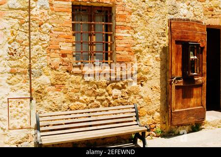 Panca vuota di fronte a un muro, Monteriggioni, Provincia di Siena, Toscana, Italia Foto Stock