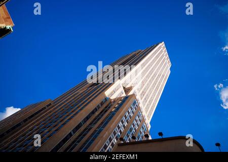 Vista ad angolo basso dei grattacieli, dell'Empire state Building, di Manhattan, di New York City, dello stato di New York, STATI UNITI Foto Stock