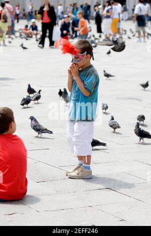 Profilo laterale di un ragazzo in piedi e che indossa una maschera, Venezia, Veneto, Italia Foto Stock