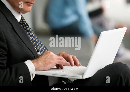Close up di un professore che usa un laptop in un corridoio Foto Stock