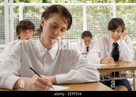 Studenti delle scuole superiori che danno un esame in classe Foto Stock