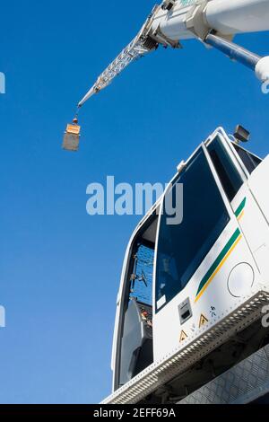 Vista ad angolo ridotto di una gru che trasporta un contenitore di carico Foto Stock