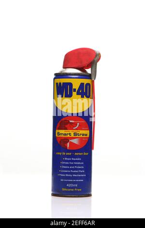 Vecchia lattina usata di WD-40 scattata su sfondo bianco con riflessione Foto Stock