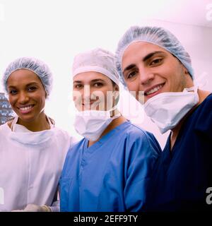 Ritratto di un chirurgo maschile e due chirurghi femminili sorridenti Foto Stock