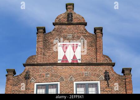 Colroful gable casa con finestre blu e porta e colroful parete blu chiaro Foto Stock