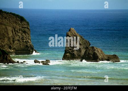 Vista laterale di un dolce surf che si infrangono su rocce in riva al mare, Santa Lucia, Caraibi Foto Stock