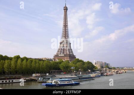 Barche Tourboats ormeggiate in un fiume vicino a una torre, Torre Eiffel, Senna, Parigi, Francia Foto Stock