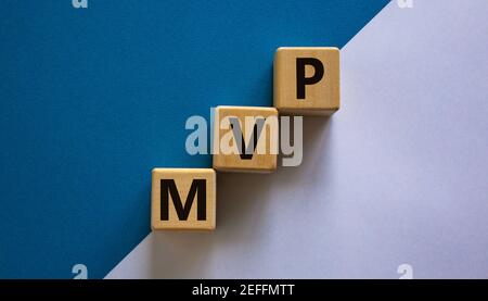 MVP, simbolo del prodotto minimo. Cubetti di legno con la parola MVP, prodotto minimo vitale. Splendido sfondo bianco e blu. Business e MVP, min Foto Stock