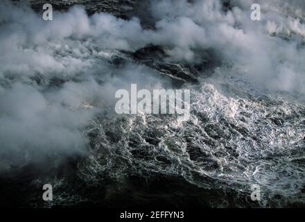 Il vapore sale dalla lava che scorre nel mare, Hawaii Foto Stock