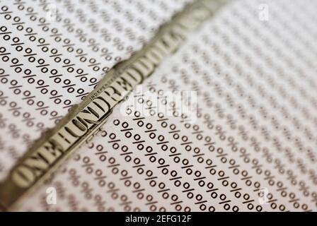 Primo piano di un conto di un centinaio di dollari sotto una lacerata carta Foto Stock