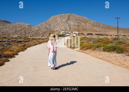 FOLEGANDROS, Grecia - 25 settembre 2020: Una donna turistica che si trova sulla strada della costa meridionale dell'isola di Folegandros. CICLADI, Grecia Foto Stock