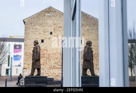 16 febbraio 2021, Renania-Palatinato, Treviri: La statua di Karl Marx su Simeonstiftplatz si riflette in una finestra. La statua fu svelata il 5 maggio 2018 in occasione del 200° anniversario della nascita di Karl Marx nella sua città natale. Il filosofo, economista, giornalista e autore del "capitale", critica della società capitalista del XIX secolo, è nato a Treviri il 5 maggio 1818. Foto: Andreas Arnold/dpa Foto Stock