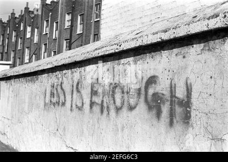 UK, West London, Notting Hill, 1973. Grafitti dice 'meno è sufficiente'. Foto Stock