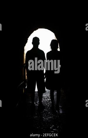 Silhouette di un uomo e di una donna in piedi in un arco, Diamond Head, Waikiki Beach, Honolulu, Oahu, Isole Hawaii, Stati Uniti Foto Stock