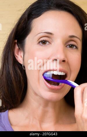 Ritratto di una metà donna adulta spazzolare i suoi denti Foto Stock