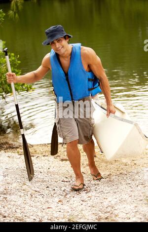 Vista ad angolo alto di un uomo medio adulto che porta un kayak e un rombo Foto Stock