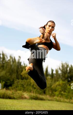 Vista ad angolo basso di una donna mid adulta che pratica marziale arte Foto Stock