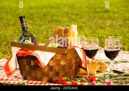 Primo piano di una bottiglia di vino con pane e frutta un cestino da picnic Foto Stock