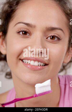 Ritratto di una giovane donna con uno spazzolino davanti della sua bocca Foto Stock