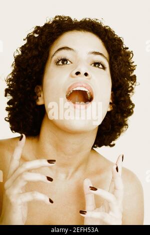 Primo piano di una giovane donna che guarda sorpresa Foto Stock