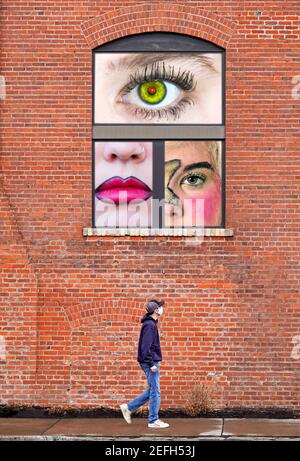 Ti sto guardando. Un uomo cammina sotto una finestra come una donna guarda dall'alto. Immagine composita. Foto Stock