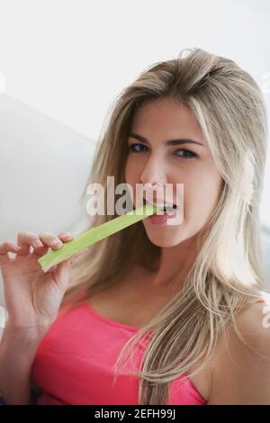 Ritratto di una donna mid adulta che mangia sedano Foto Stock