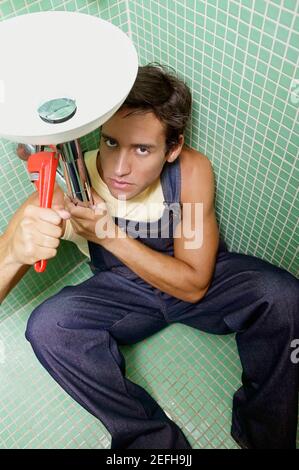 Ritratto di un giovane che ripara un lavabo Foto Stock