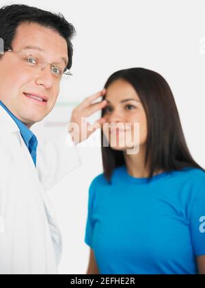 Close up di un medico maschile che conduce un esame oculare su una paziente di sesso femminile Foto Stock