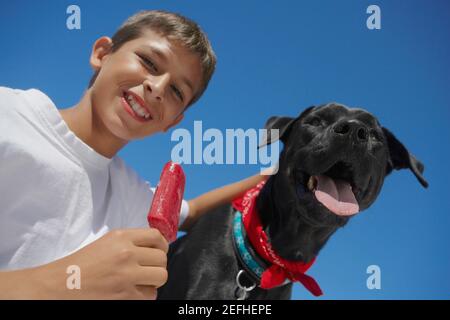 Ritratto di un ragazzo adolescente che tiene gelato con un cane Foto Stock