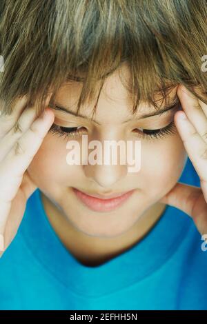 Primo piano di un ragazzo con la testa nelle mani Foto Stock