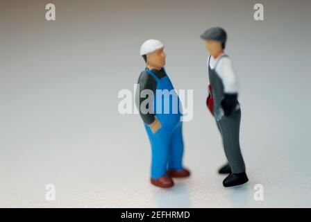 Primo piano delle figurine di due operai edili Foto Stock