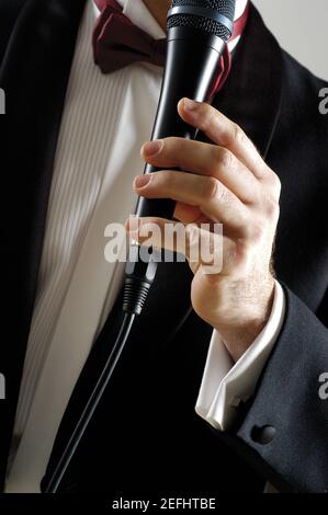 Vista in sezione intermedia di un cantante che tiene un microfono Foto Stock