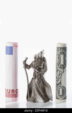 Figurine di un cassiere di fortuna tra i rotoli dell'Unione europea euro e valuta cartacea USA Foto Stock