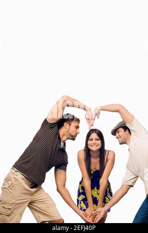 Metà uomo adulto e un giovane uomo che fa a forma di cuore di fronte a una giovane donna Foto Stock