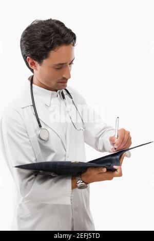 Medico maschio di scrittura in un file Foto Stock