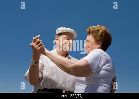 Vista ad angolo basso di una coppia senior che balla Foto Stock