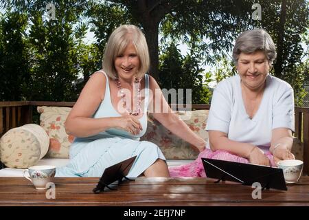 Due donne che si siedono su un divano e giocano a mahjong Foto Stock