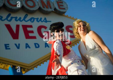 Uomo medio adulto e una donna mid adult vestita in costumi, Las Vegas, Nevada, USA Foto Stock