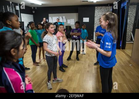 Gli studenti partecipano a una lezione di educazione fisica indoor (PE) in una scuola nel sud-est di Londra, Inghilterra, Regno Unito Foto Stock