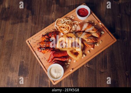 Ampia selezione di snack per la birra con diverse salse su pergamena vista superiore Foto Stock