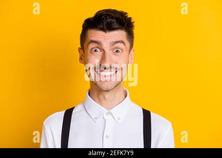 Primo piano ritratto di simpatico simpatico ragazzo allegro che indossa una camicia bianca sorridente isolato su uno sfondo di colore giallo brillante Foto Stock